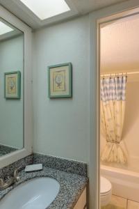 bagno con lavandino, servizi igienici e specchio di Tiki 218 a South Padre Island