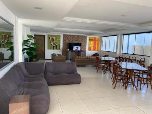 sala de estar con sofá, mesas y sillas en Hotel Algas Marinhas, en Aracaju