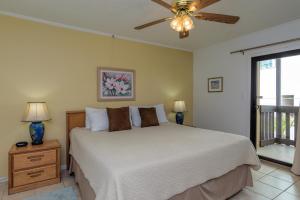 una camera con letto e ventilatore a soffitto di Tiki 218 a South Padre Island