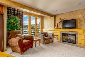 a living room with two chairs and a fireplace at Shoshone 1972 in Big Sky Mountain Village