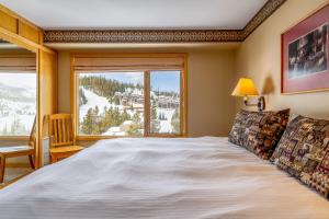Big Sky Mountain VillageにあるShoshone 1972の大きなベッドと大きな窓のある寝室