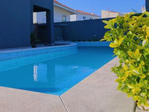 una piscina azul frente a una casa en Vila Hotel By VimaHotels, en Guimarães