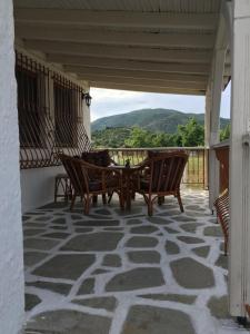 a patio with a table and chairs on a balcony at Andronikis House in Sykia Chalkidikis