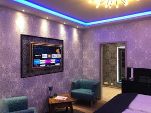 a bedroom with purple walls and a tv on the wall at City Luxus Appartement nähe Köln Messe - LANXESS Arena in Cologne