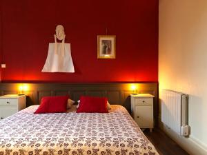 a bedroom with red walls and a bed with red pillows at Château des Edelins in Bayet