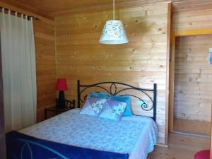 ein Schlafzimmer mit einem Bett in einem Blockhaus in der Unterkunft Casa de Sao Joao in Gandarela