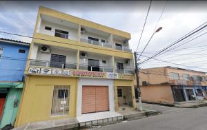 a yellow and white building with a balcony at Apart-Norte Flat Belém Aeroporto in Belém