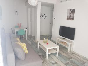 salon z białą kanapą i telewizorem w obiekcie APT 6 - Apartamento en la playa de El Palo w Maladze