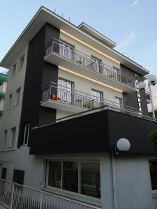 - un bâtiment noir et blanc avec un balcon dans l'établissement Hotel Brennero, à Rimini