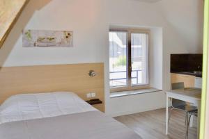 sypialnia z łóżkiem, biurkiem i oknem w obiekcie La petite maison appartement 2 w mieście Avoine