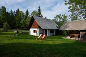 a barn with two chairs in front of a yard at Holiday Home Srednja vas in Srednja Vas v Bohinju