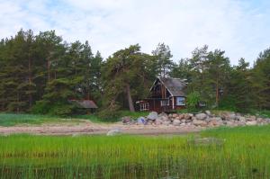 une petite maison au bord d'une rivière avec des rochers dans l'établissement Karineeme Holiday House, à Mahu