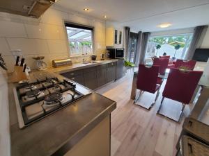 a kitchen with a stove and a dining room at Chalet nr 30 in Putten in Putten