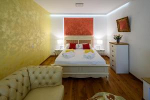 1 dormitorio con cama blanca y sofá en Ultracentral luxury apartment, en Cluj-Napoca