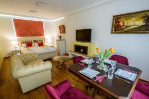 ein Wohnzimmer mit einem Tisch, einem Sofa und einem Bett in der Unterkunft Ultracentral luxury apartment in Cluj-Napoca