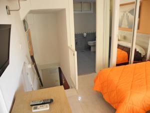 a bedroom with an orange bed and a bathroom at JSM Apartamentos in Benalmádena