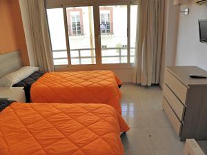 a hotel room with two beds and a window at JSM Apartamentos in Benalmádena