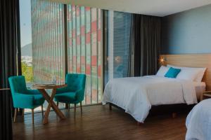 ein Hotelzimmer mit Bett, Tisch und Stühlen in der Unterkunft Hotel Kavia Monterrey in Monterrey + 77 Fotos