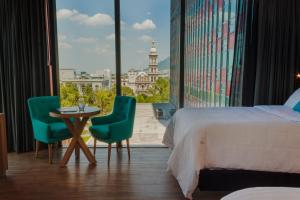une chambre d'hôtel avec un lit, une table et des chaises dans l'établissement Hotel Kavia Monterrey, à Monterrey