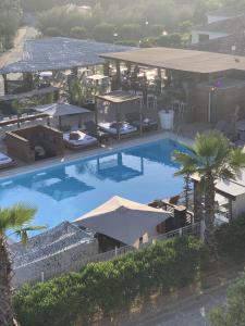 an overhead view of a large swimming pool with umbrellas at APPARTEMENT DUPLEX PORTICCIO Centre in Porticcio