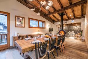 uma sala de jantar com uma grande mesa de madeira e cadeiras em MORZINE GUEST CHALET HYPERCENTER Jacuzzi et Sauna em Morzine