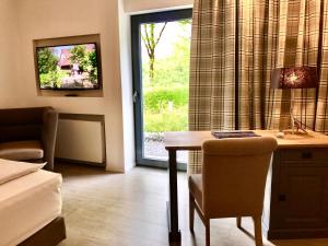 a hotel room with a desk and a window at Park Villa in Wuppertal