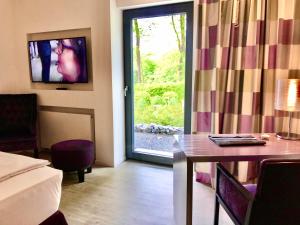 a room with a room with a table and a television at Park Villa in Wuppertal