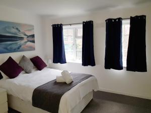een slaapkamer met een groot bed en blauwe gordijnen bij Barnfield Place in Edgware