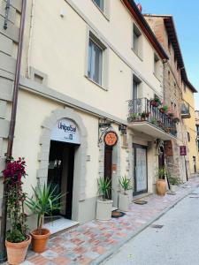 een gebouw op een straat met potplanten ervoor bij L'Arco B&B di Charme in Passignano sul Trasimeno