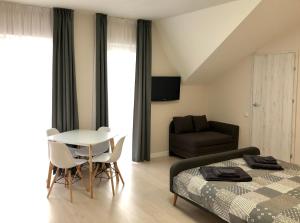 a bedroom with a bed and a table and a chair at Apartamentai Klaipėda-studijos tipo butukai in Klaipėda