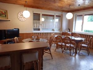 jadalnia ze stołami, krzesłami i zegarem w obiekcie Ferienwohnungen Ödenburgerhof w mieście Mörbisch am See