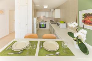 a kitchen with a table with plates and a vase of flowers at Residence Playa Paraiso With Ocean View in Costa Calma