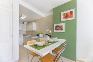 una cucina e una sala da pranzo con tavolo e sedie bianchi di Residence Playa Paraiso With Ocean View a Costa Calma
