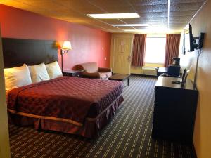 Habitación de hotel con cama y silla en Executive Inn & Suites Prescott, en Prescott