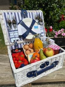 uma cesta cheia de frutas e legumes sobre uma mesa em Bed & Breakfast de Lindevallei em Oldeberkoop