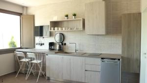 una cucina con lavandino e bancone con sgabelli di siviri suites a Siviri
