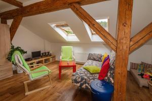 a attic room with a bed and a desk and chairs at Apartman Charlie in Smržovka