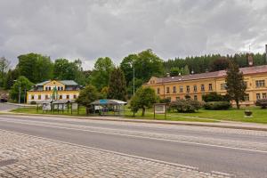 an empty road in front of a large building at Apartman Charlie in Smržovka
