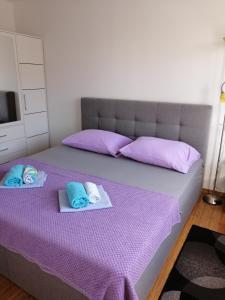Un dormitorio con una cama morada con toallas. en Apartment Mery, en Trogir
