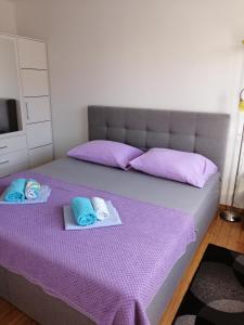 a bedroom with a purple bed with towels on it at Apartment Mery in Trogir