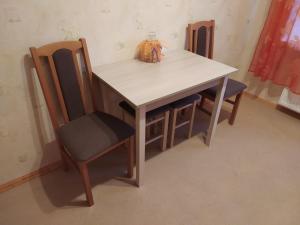 a table with two chairs and a table and a table and chairsuggest at Rojas street apartments in Liepāja