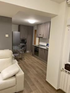 sala de estar con sofá y cocina en piso avenida 49, en Gijón