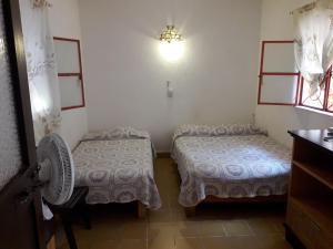 a room with two beds and a fan and a window at Hotel Ana Liz in Puerto Vallarta