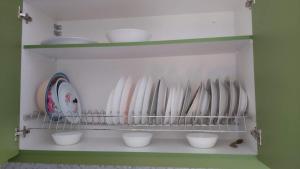 a shelf with white bowls and plates on it at Marko's Cozy Apartment in Megalochori