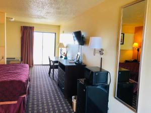 a hotel room with a bed and a desk with a television at Executive Inn & Suites Prescott in Prescott