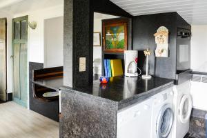 een keuken met een wasmachine in de kamer bij Chalet Den Keibilk in Heuvelland