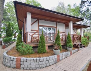 a small house with a porch and some plants at Ameba Resort in Mielno