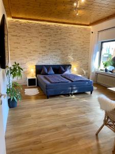 a bedroom with a blue bed and a brick wall at Puppi' s Nest mit Alpspitzblick in Garmisch- Partenkirchen in Garmisch-Partenkirchen