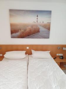 two beds in a room with a picture of a lighthouse at Ferienwohnung Sonnenblick mit 3 Zimmer und Balkon in Zempin