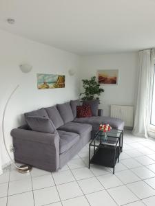 a living room with a gray couch and a table at Ferienwohnung Sonnenblick mit 3 Zimmer und Balkon in Zempin